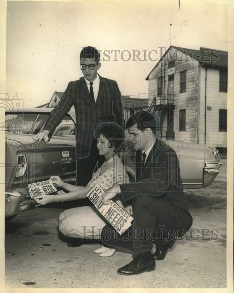 1965 Press Photo Shields Stutts & LSUNO students place bumper sticker on car- Historic Images