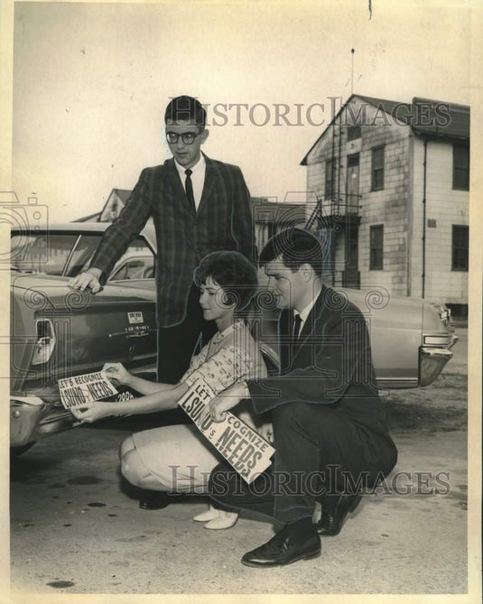 1965 Press Photo Shields Stutts & LSUNO students place bumper sticker on car- Historic Images