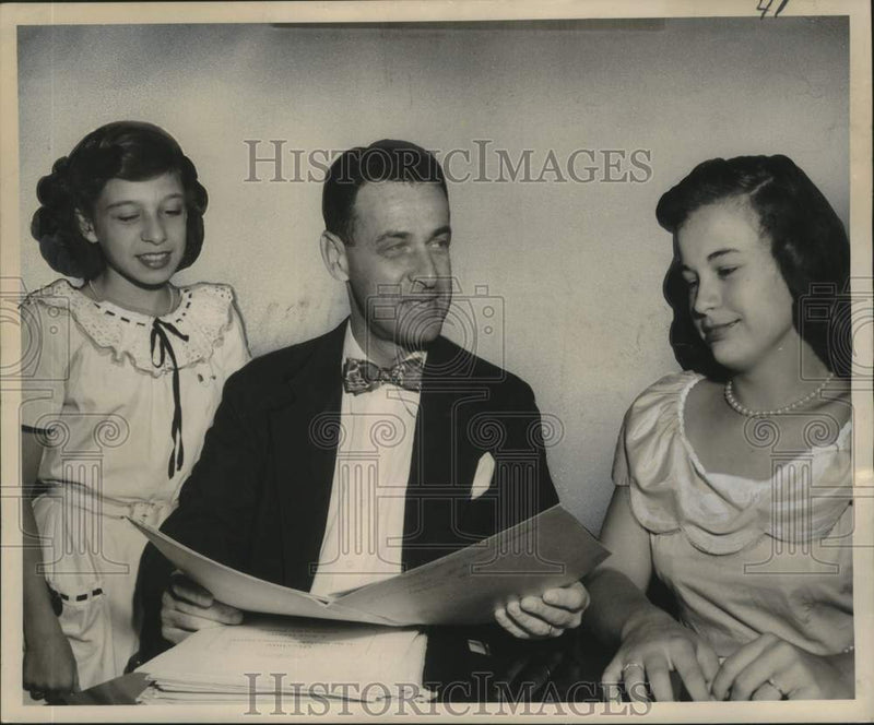 Load image into Gallery viewer, 1949 Press Photo Conductor talks to teens about scores for their solos
