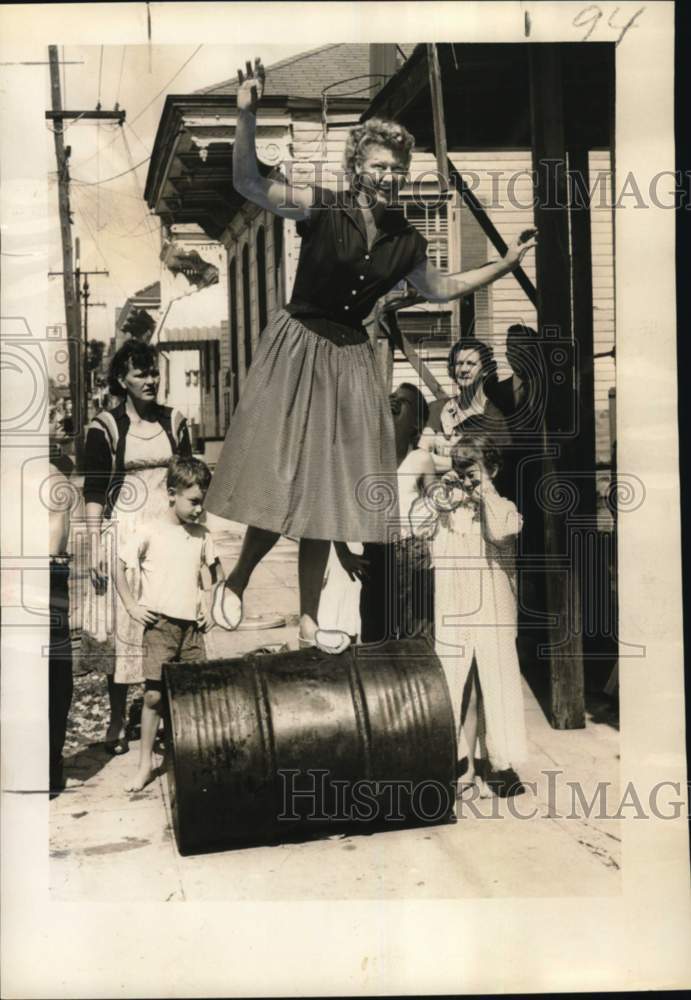 1956 Press Photo Mrs. Edward Winn walks on Barrels in front of Children- Historic Images