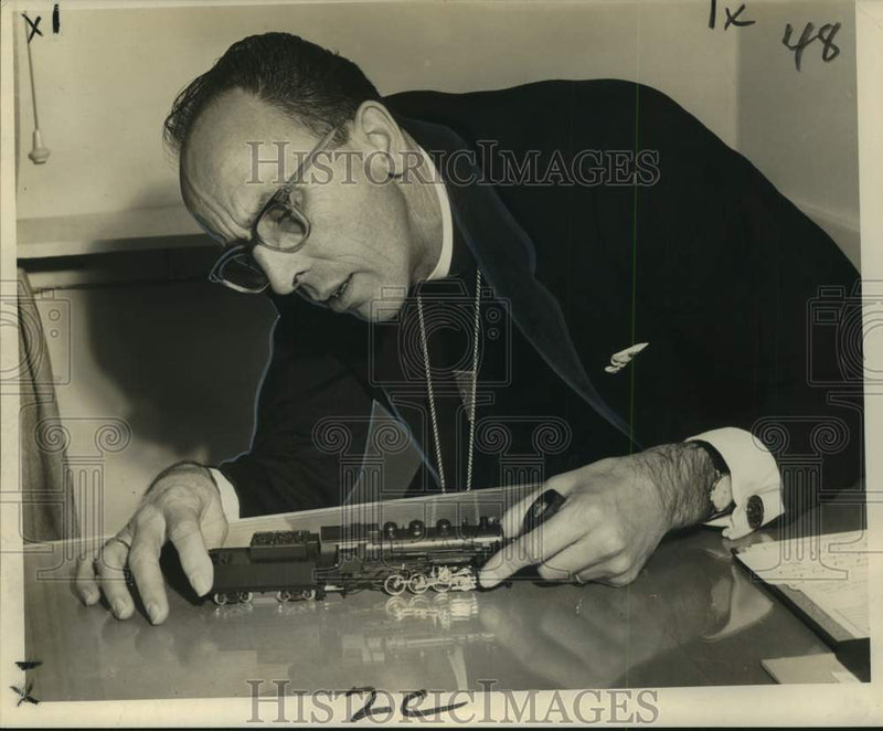 Load image into Gallery viewer, 1966 Press Photo Reverend Eugene Warner examines farewell model train gift.
