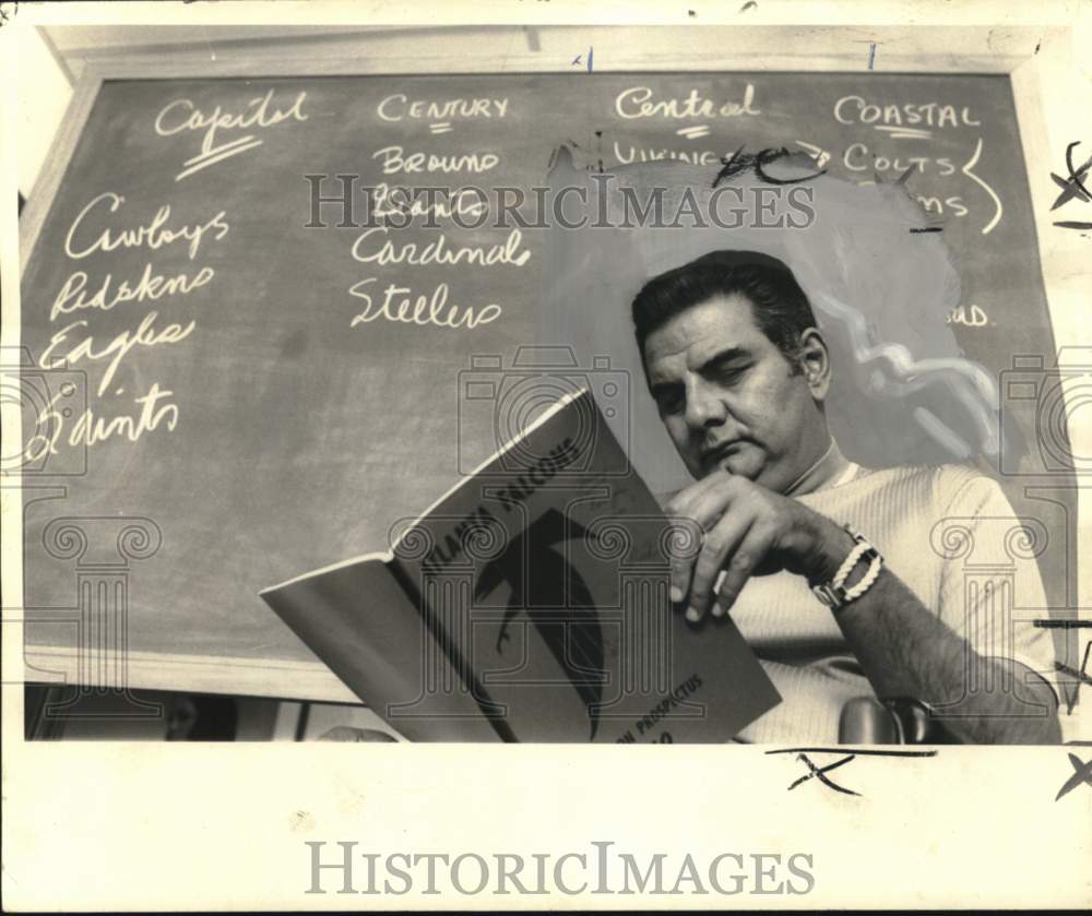 1969 Press Photo Jimmy Snyder ponders Falcons chances reading Football Material- Historic Images