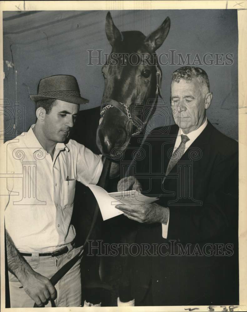 1963 Press Photo Trainer J.B. Sonnier, Blue Trumpet and owner check racing form- Historic Images