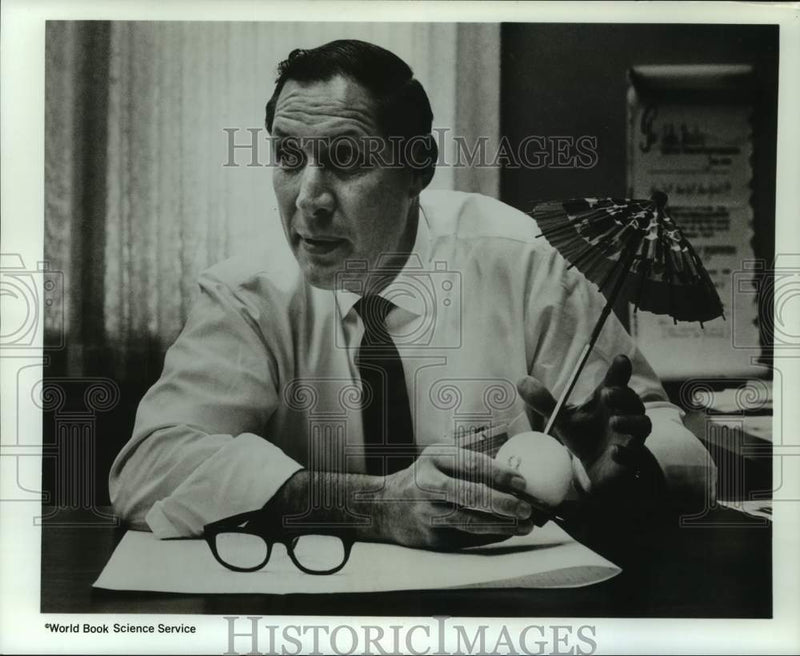 Load image into Gallery viewer, 1968 Press Photo John Healy with a paper parasol stuck in a plastic 8-ball
