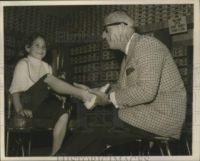 Load image into Gallery viewer, 1960 Press Photo Harry Karl slips a shoe onto a young girl's foot - nop42982
