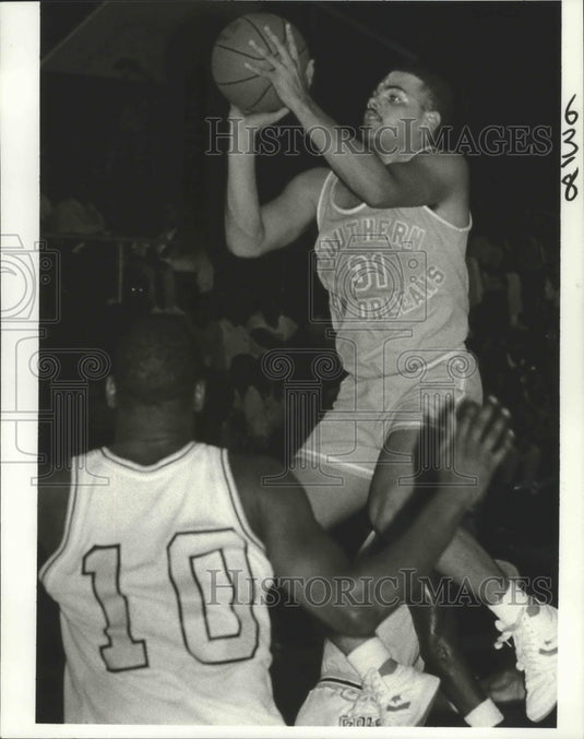 1986 Press Photo Basketball- SUNO's Wayne Knight Jumps Over Xavier's Kenny Loyd- Historic Images