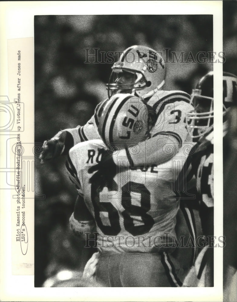 1987 Press Photo Ruffin Rodrigus picks up Victor Jones after Football Touchdown- Historic Images