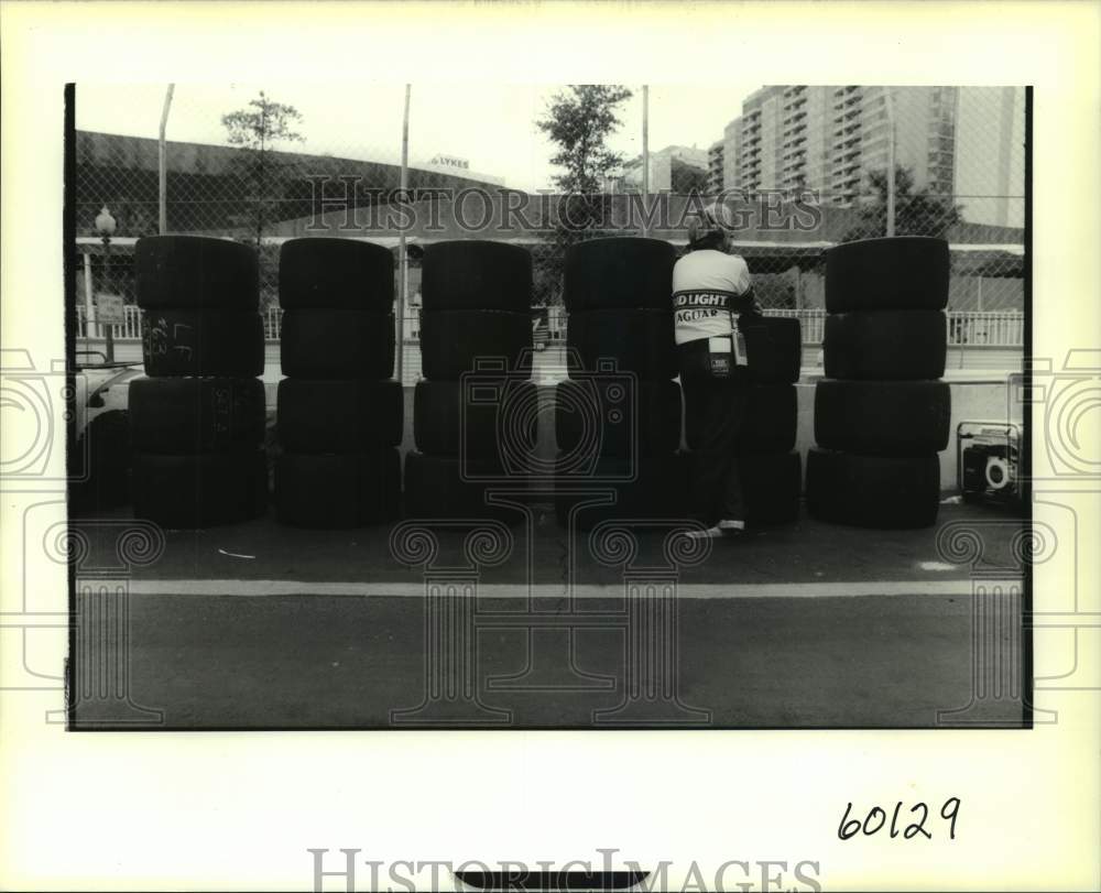 1991 Press Photo A Grand Prix du Mardi Gras race crew member with tire stacks- Historic Images