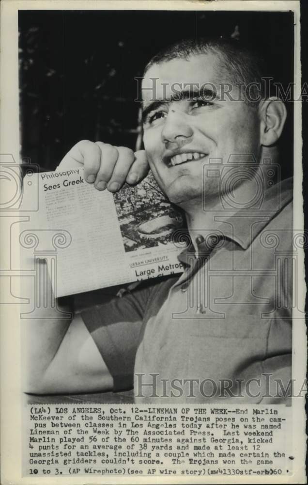 1960 Press Photo USC football player Marlin McKeever holds up newspaper - Historic Images