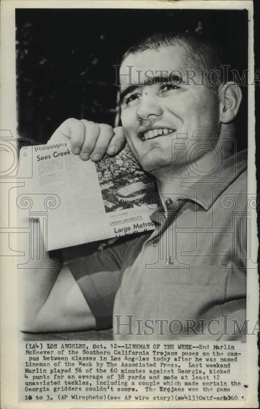 1960 Press Photo USC football player Marlin McKeever holds up newspaper - Historic Images