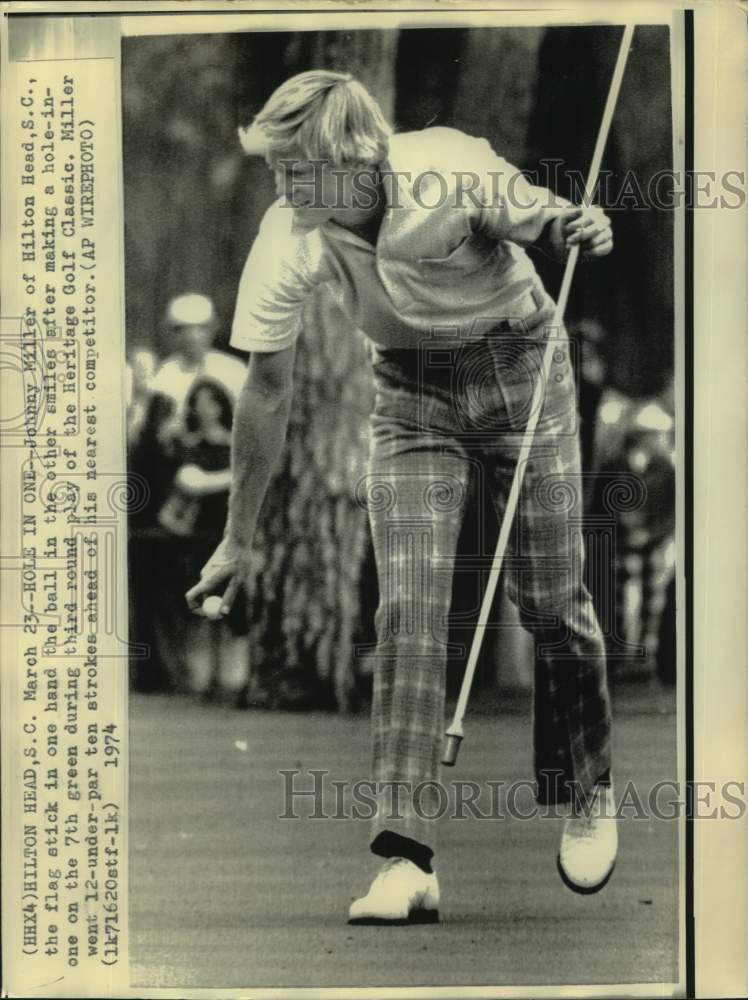 1974 Press Photo Golfer Johnny Miller holds ball in one hand, flagstick in other- Historic Images