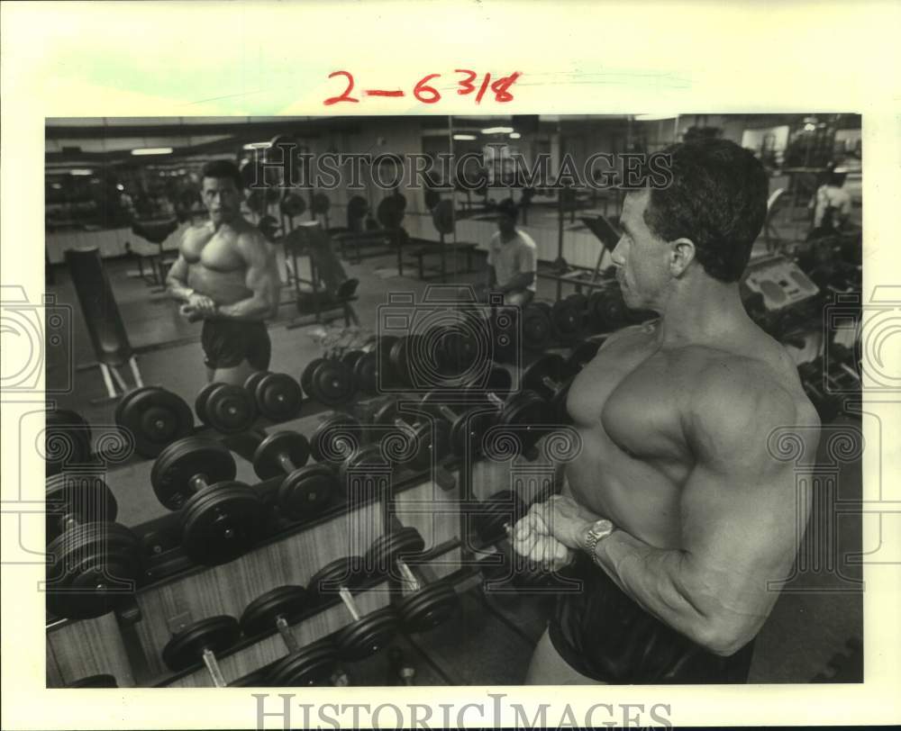 1984 Press Photo Bodybuilder Brad Mason checks out a pose in a mirror in club- Historic Images