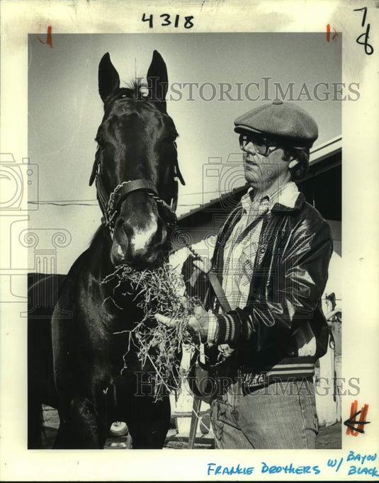 1981 Press Photo Race horse Bayou Black with trainer Frankie Brothers, eats hay- Historic Images