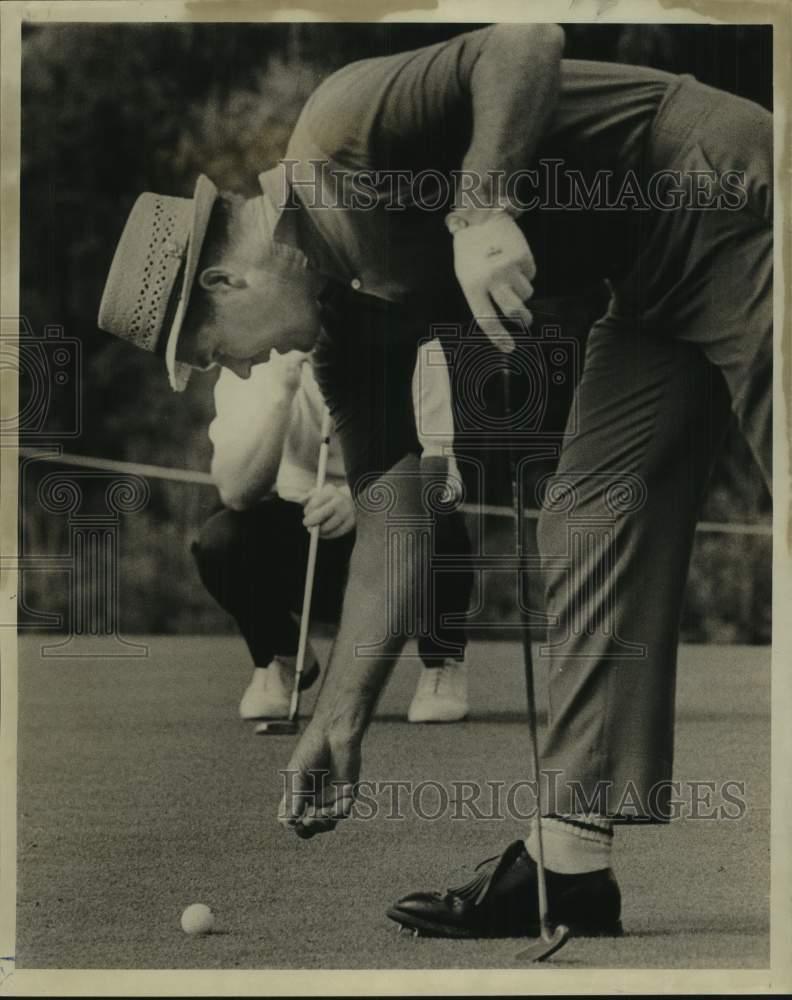 1967 Press Photo Golfer Kel Nagle bends over to mark his ball on the green- Historic Images