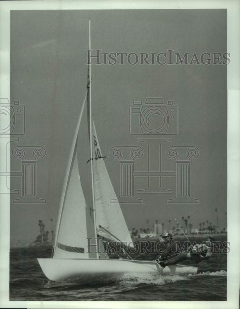 1984 Press Photo Two men lean over the side of a sailboat during a race- Historic Images