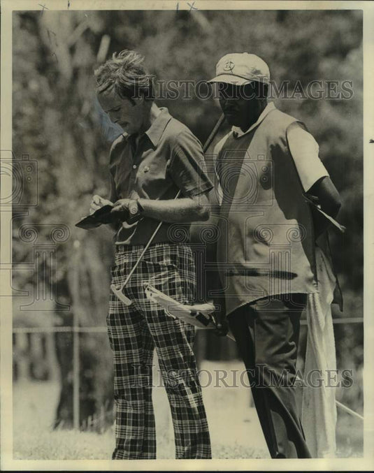 1975 Press Photo Golfer Larry Nelson checks out scorecard with caddie watching- Historic Images
