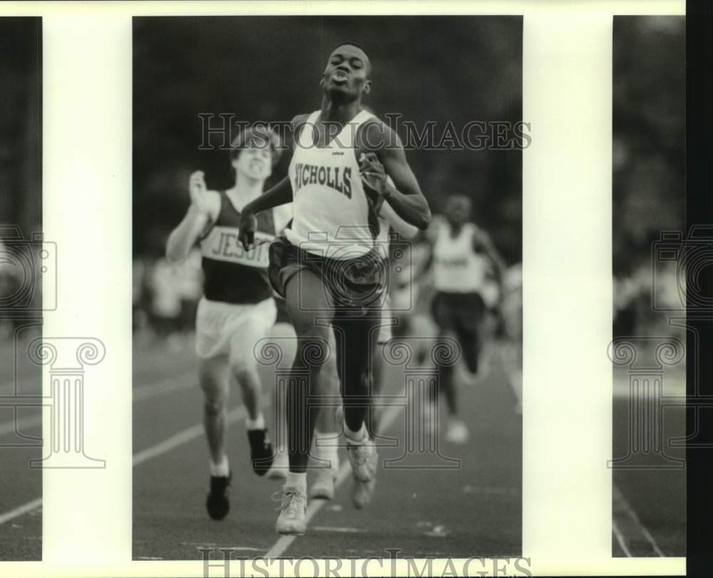 Press Photo Nicholls High School track athlete runs ahead of runner from Jesuit- Historic Images