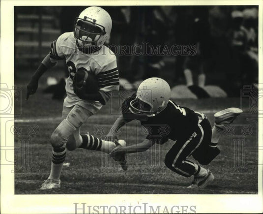 1984 Press Photo Harvey Saint football running back Shombe Boston eludes tackle- Historic Images