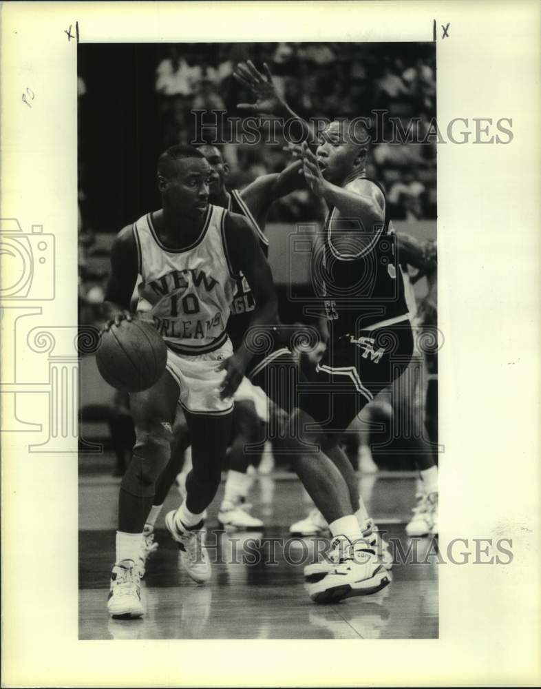 1990 Press Photo UNO basketball player Willie Richardson dribbles by defender- Historic Images