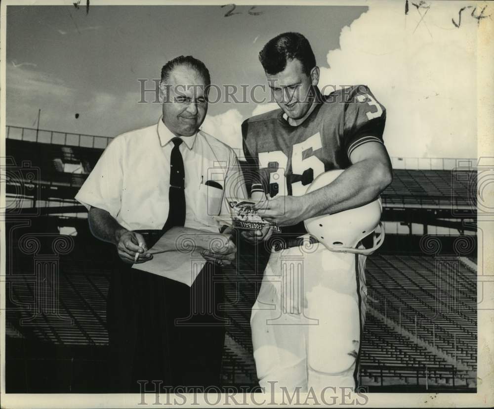 1967 Press Photo Tulane football coach Andy Pilney reviews book with player #35- Historic Images