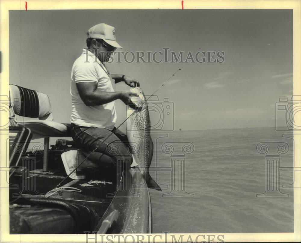 1990 Press Photo Fisherman Catches Redfish and Releases - nos30081- Historic Images