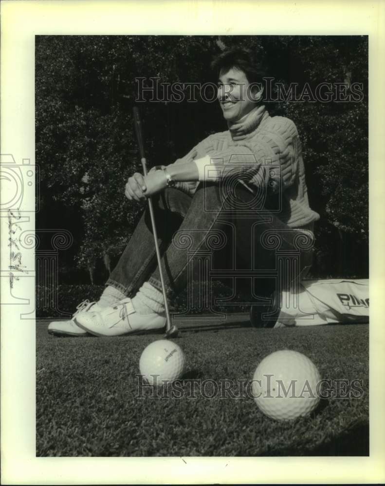 1989 Press Photo Golfer Dr Lori Rogers sits on her golf bag with a big smile- Historic Images