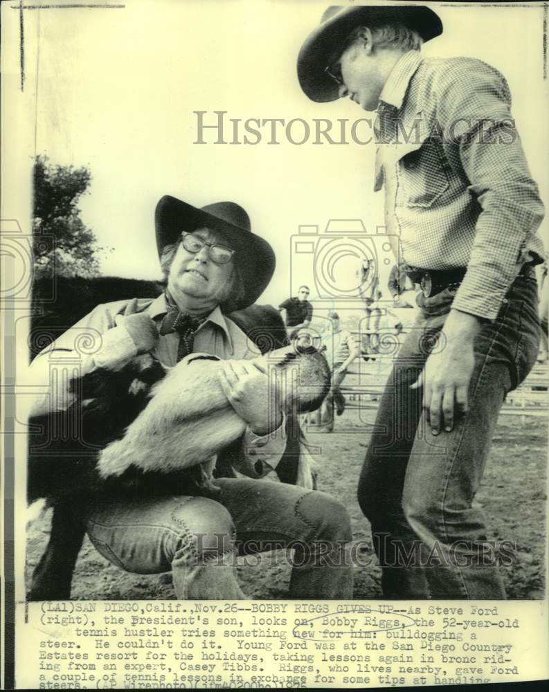 1975 Press Photo Tennis player Bobby Riggs bulldogging a steer with Steve Ford- Historic Images