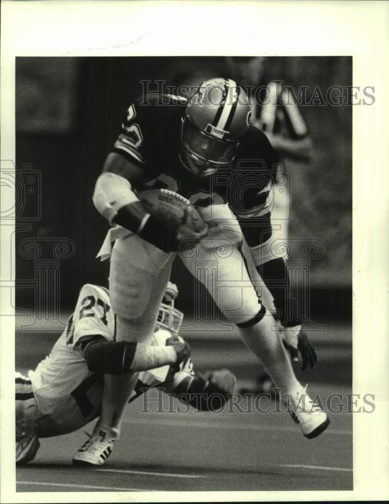 1983 Press Photo New Orleans Saints football player George Rogers avoids tackle- Historic Images