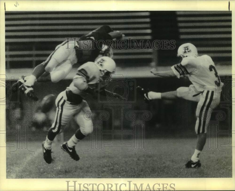 1990 Press Photo Football player kicks the ball as defender leaps to block it- Historic Images