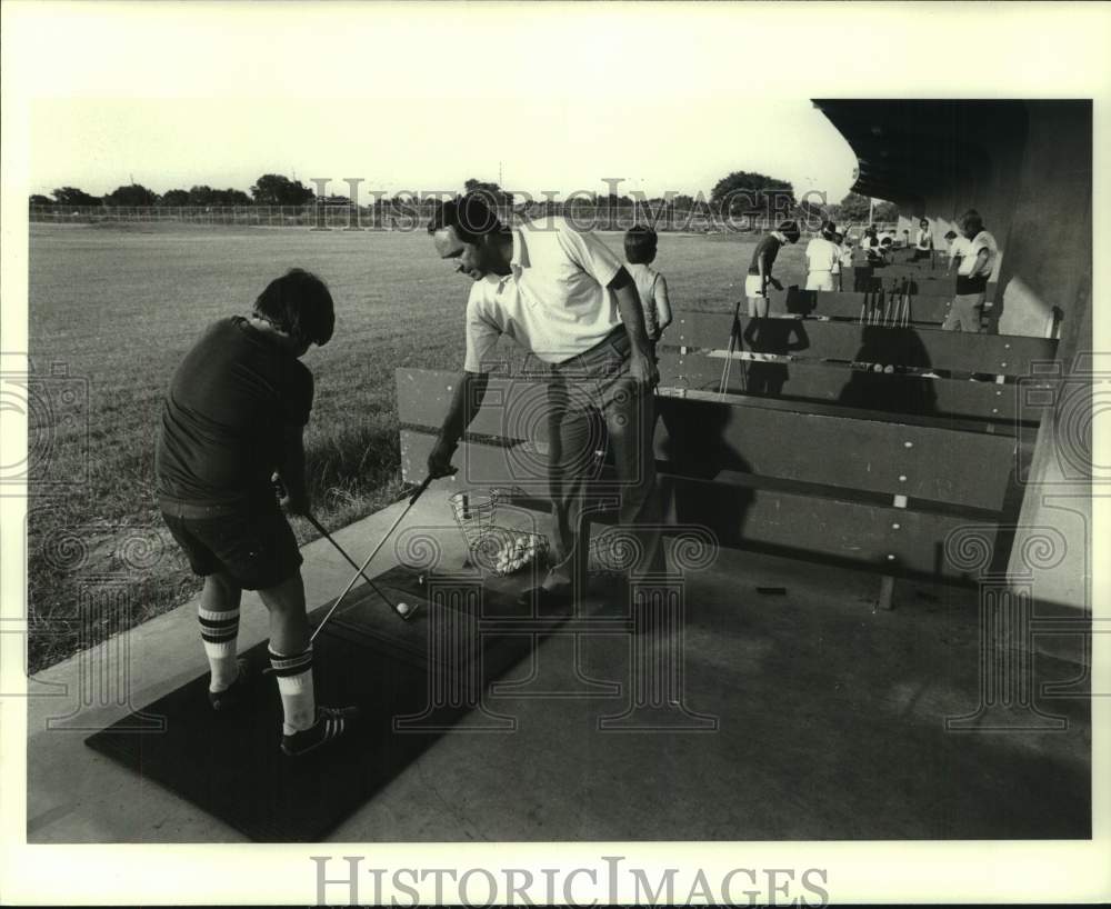 1978 Press Photo Golfer Johnny Pott gives instruction to boy on driving range- Historic Images