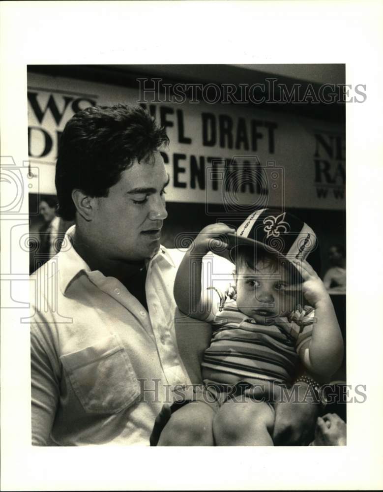 1987 Press Photo Jon Dumbauld of New Orleans Saints Holding Toddler During Draft- Historic Images