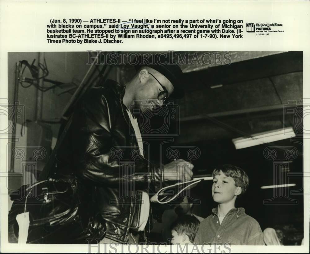 1990 Press Photo Loy Vaught, University of Michigan basketball team signs book.- Historic Images