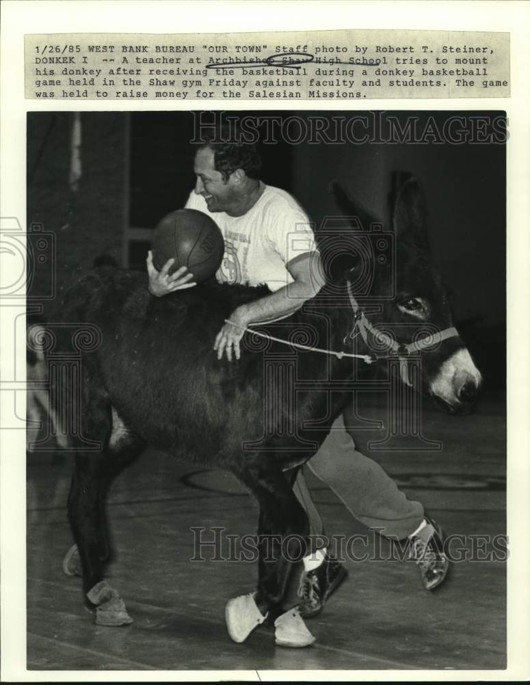 1985 Press Photo Shaw High teacher tries to mount donkey during basketball game- Historic Images