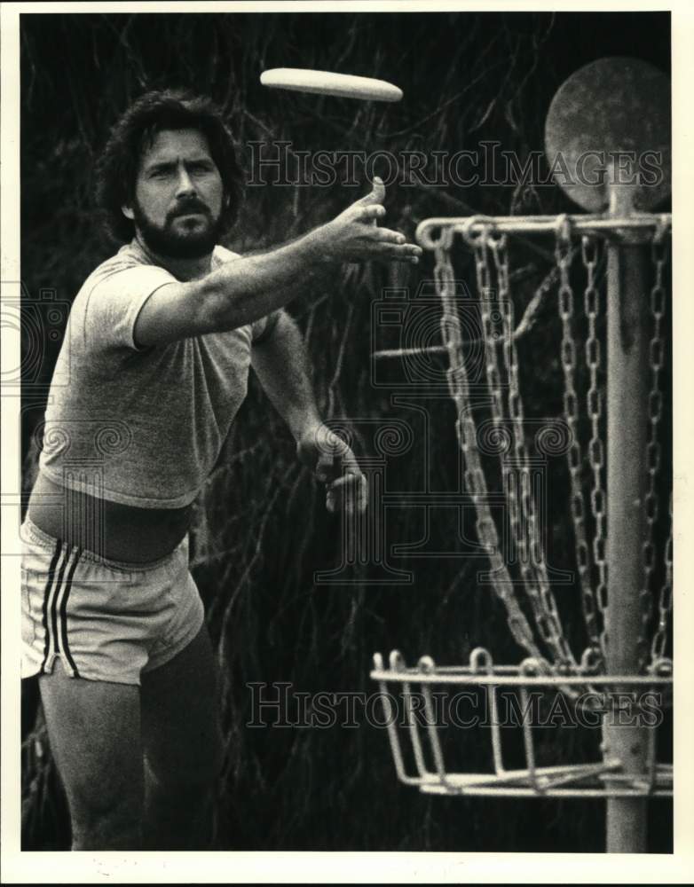 1983 Press Photo Putting the disc into a disc golf pole hole is Glenn Pizani- Historic Images