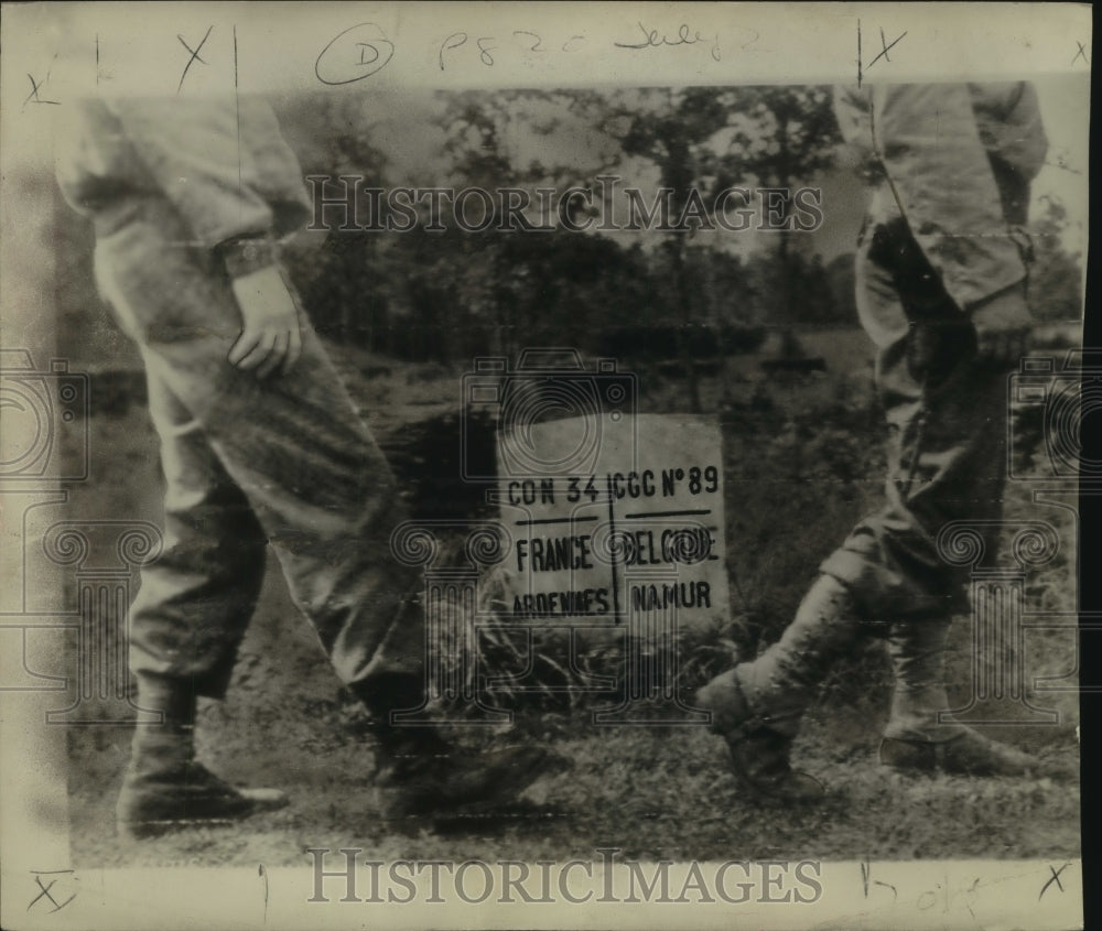 1944 Press Photo U.S. soldiers march by a marker at the Belgian-French border