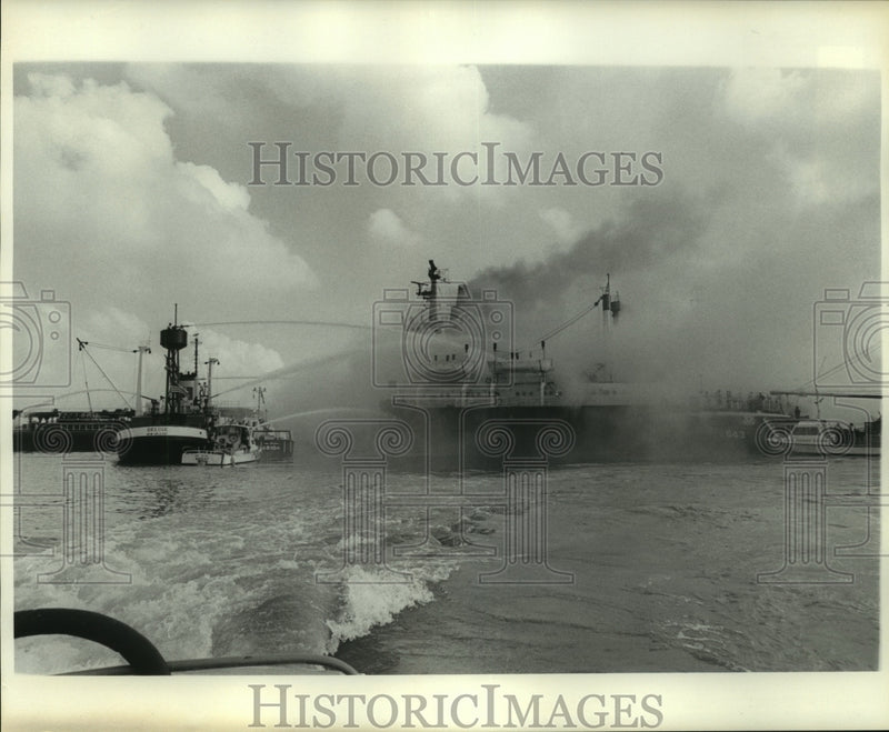 Load image into Gallery viewer, 1977 Press Photo Several boats hose down a large ship on fire in the water
