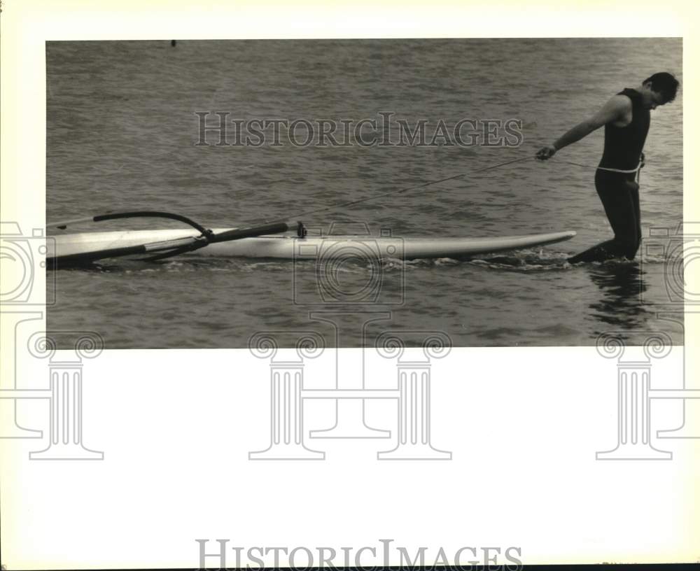 1989 Press Photo Ted Bowman tows his windsurfer at the Mandeville harbor- Historic Images