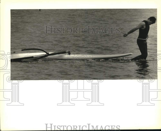 1989 Press Photo Ted Bowman tows his windsurfer at the Mandeville harbor- Historic Images