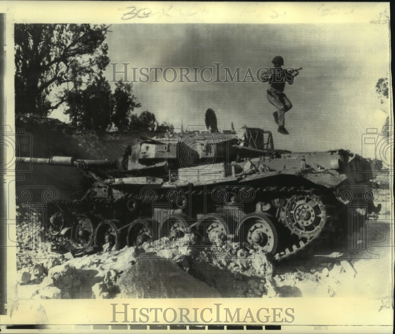 Load image into Gallery viewer, 1973 Press Photo Egyptian soldier jumps from disabled tank on Sinai Desert.
