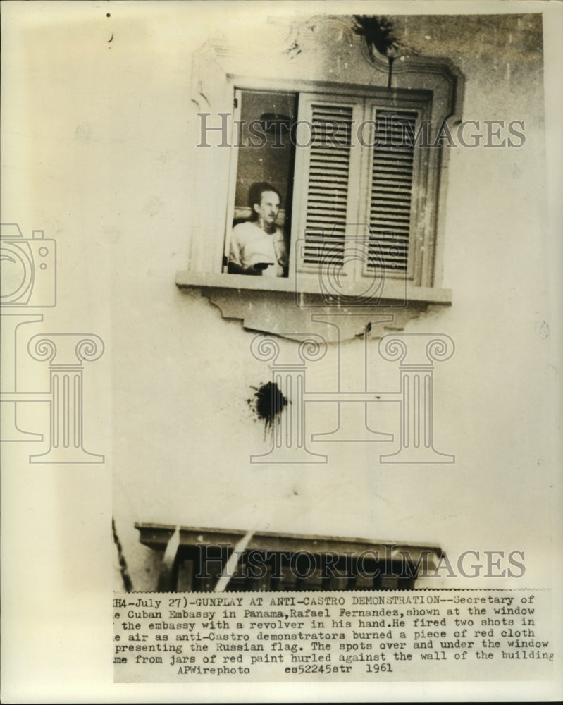 Load image into Gallery viewer, 1961 Press Photo Rafael Fernandez stands in window with revolver in his hand
