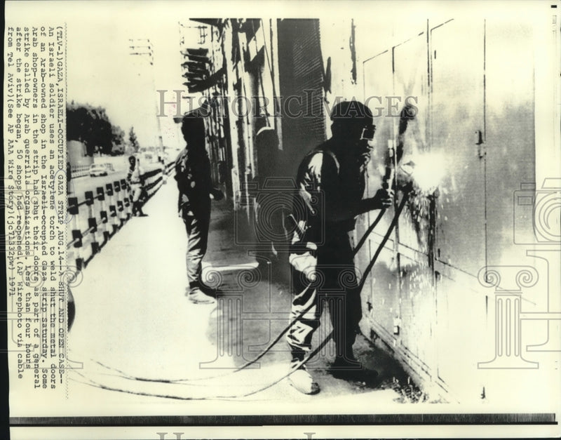 Load image into Gallery viewer, 1971 Press Photo Israeli soldier welds Arab-owned shop in Israeli-occupied Gaza
