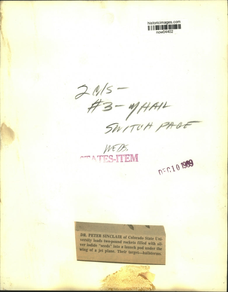 1969 Press Photo Dr. Sinclair loads "seeds" under jet wing to target hailstorms