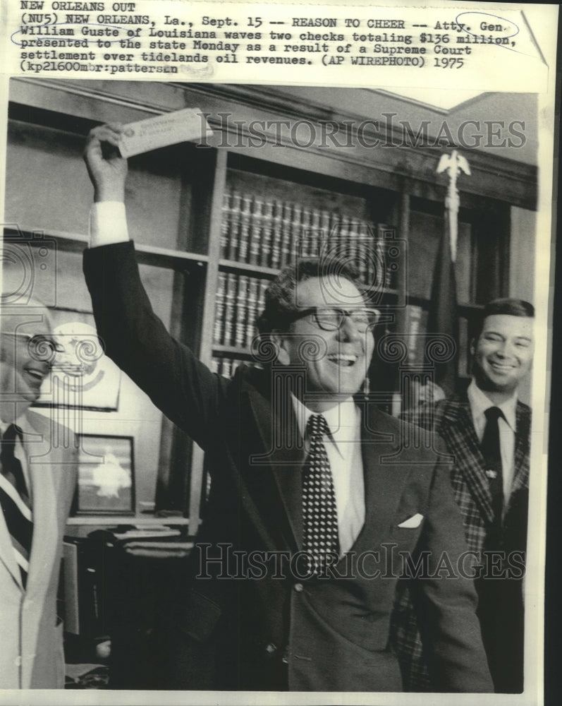 1975 Press Photo LA Attorney Gen. Guste waves checks from Supreme Court