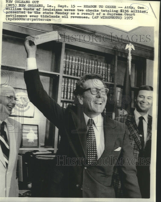 1975 Press Photo LA Attorney Gen. Guste waves checks from Supreme Court