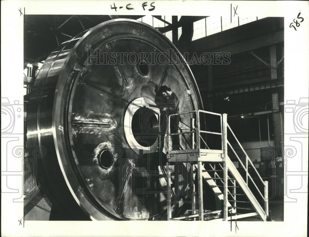 1975 Press Photo General Electric worker checks dimensions of 16-foot gear blank
