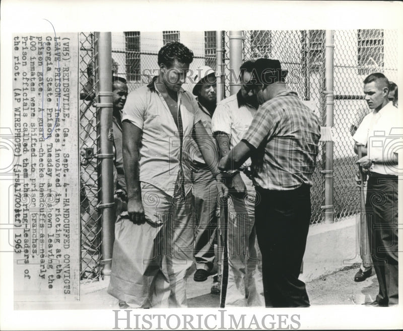 Load image into Gallery viewer, 1963 Press Photo Prison guard checks convicts handcuffs during prison transfer.
