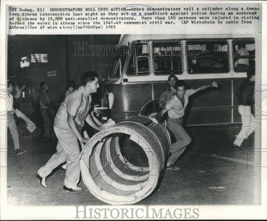 1965 Press Photo Greek demonstrators roll cylinder as a roadblock in Athens