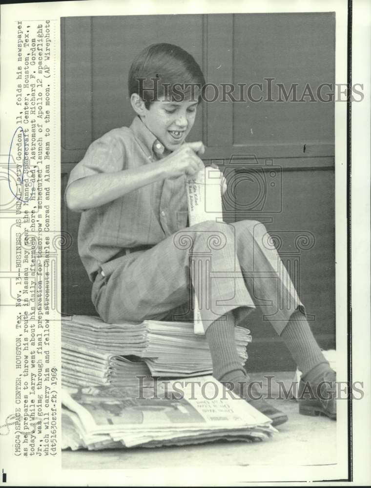 Load image into Gallery viewer, 1963 Press Photo Astronaut Richard Gordon's son Larry folds newspapers
