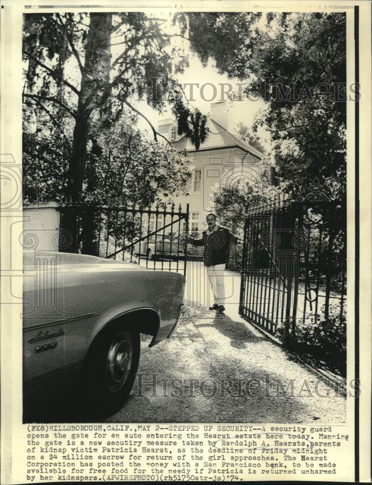 1974 Press Photo Security guard opens gate at Hearst estate in California