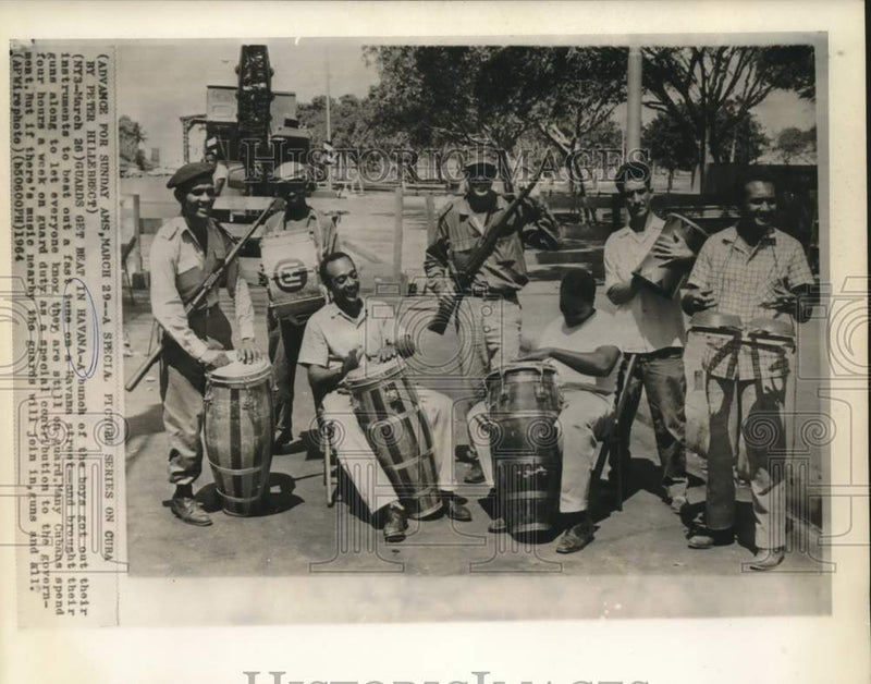 Load image into Gallery viewer, 1964 Press Photo Havana street musicians with their guard duty weapons
